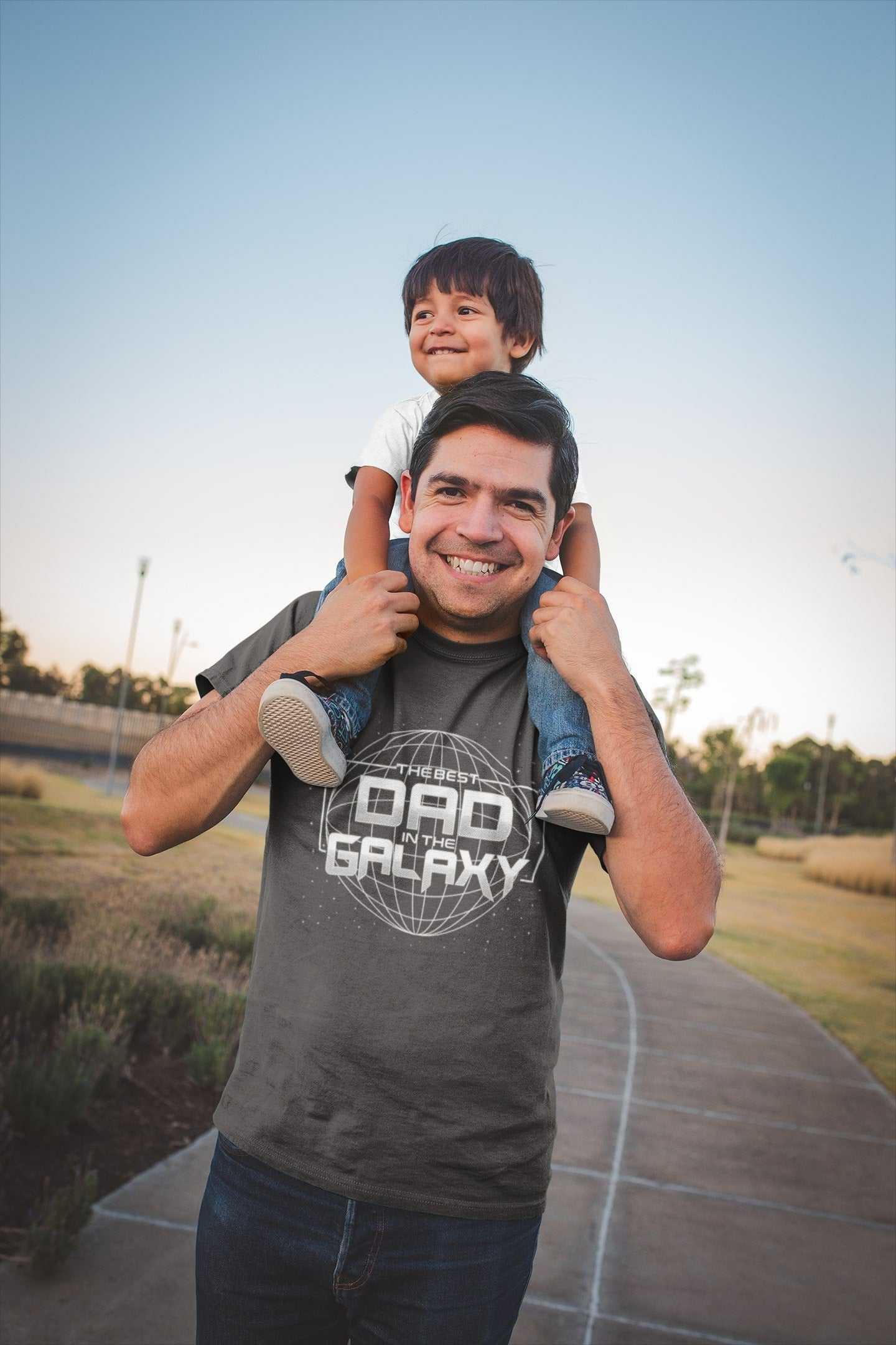 Father and child enjoying a walk; dad wearing a "Best Dad in the Galaxy" t-shirt, ideal Father's Day or Christmas gift.