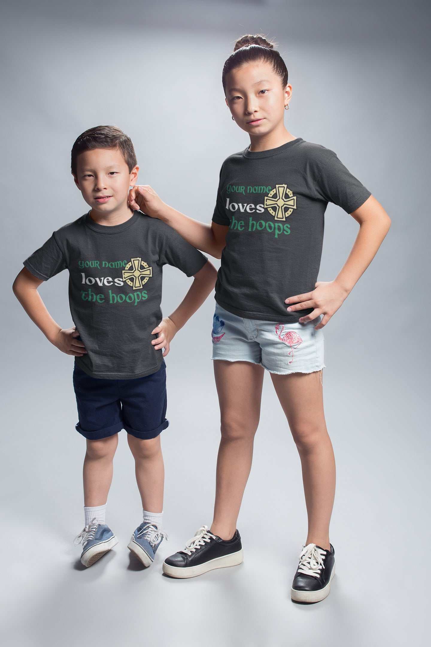 Kids wearing personalized "Loves the Hoops" football fan tees with Celtic-inspired design, customizable with names.