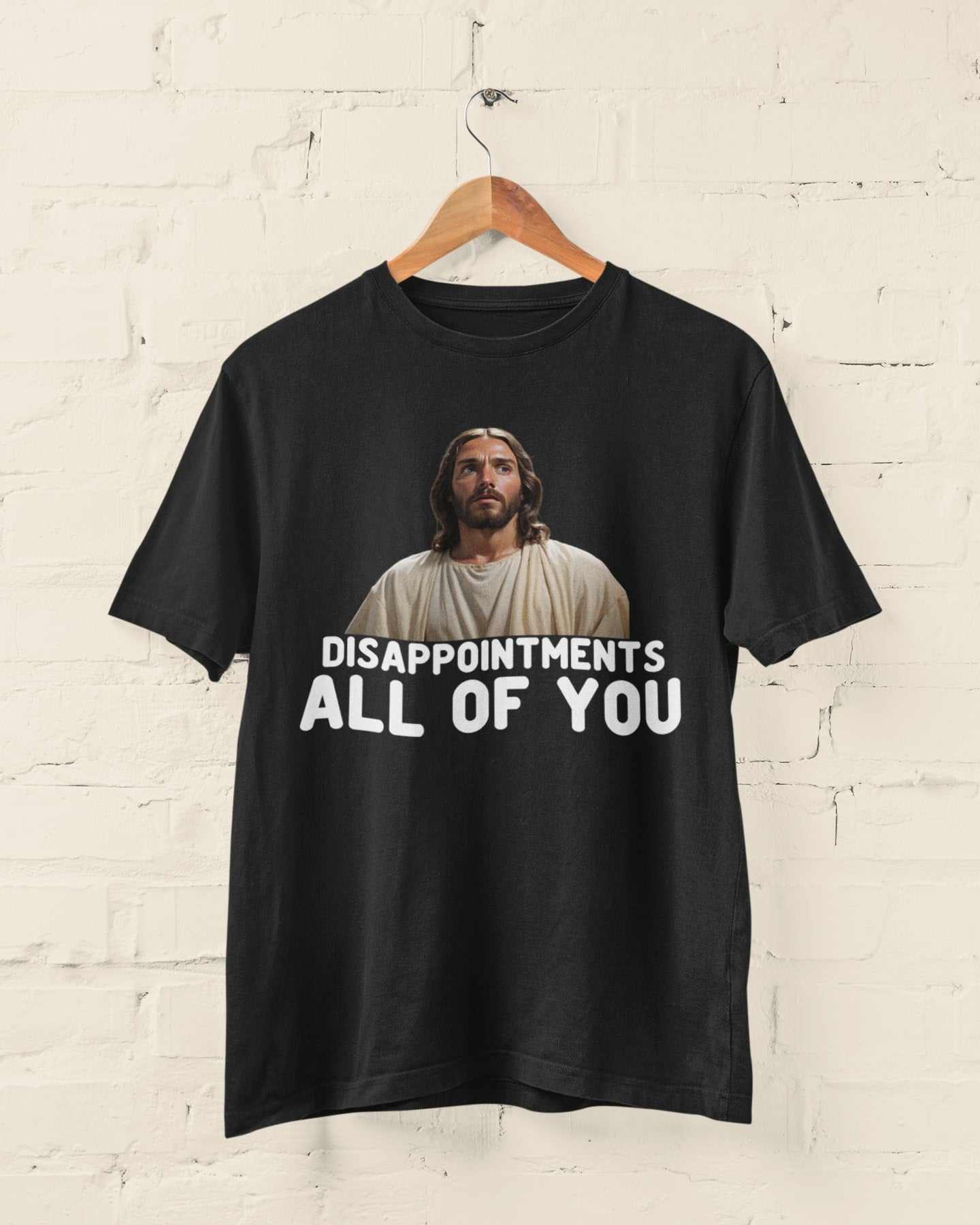 Funny Jesus Meme T-Shirt with "Disappointments, All of You" caption on black fabric.