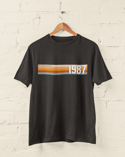 Black Established 1987 vintage strip T-shirt hanging on a wooden hanger