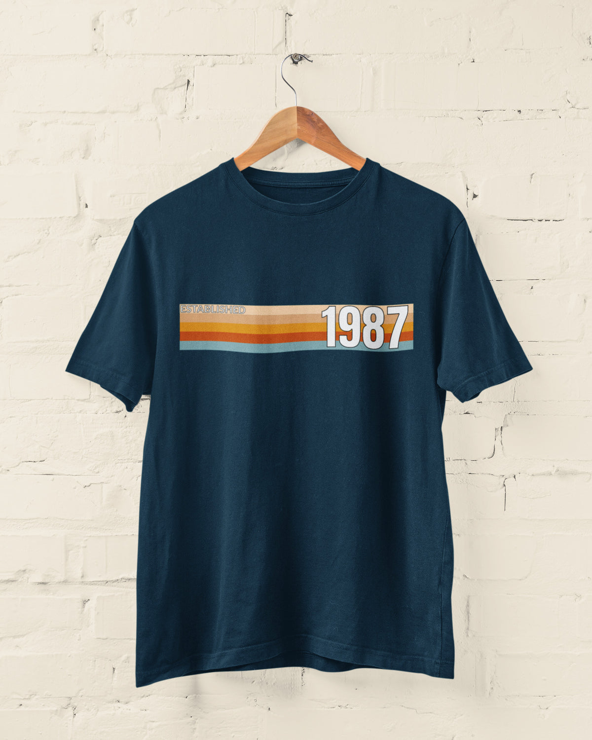 Navy Established 1987 vintage strip T-shirt hanging on a wooden hanger